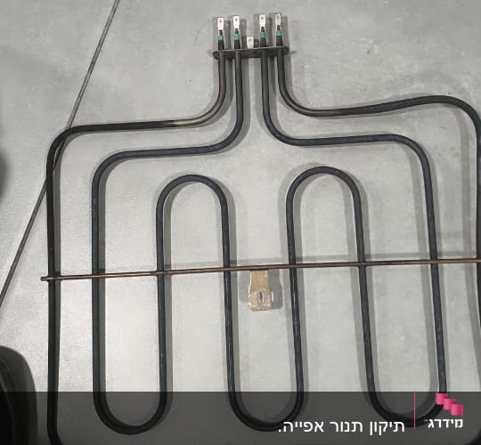 גוף חימום חשמלי עם חיבורים על רצפה אפורה